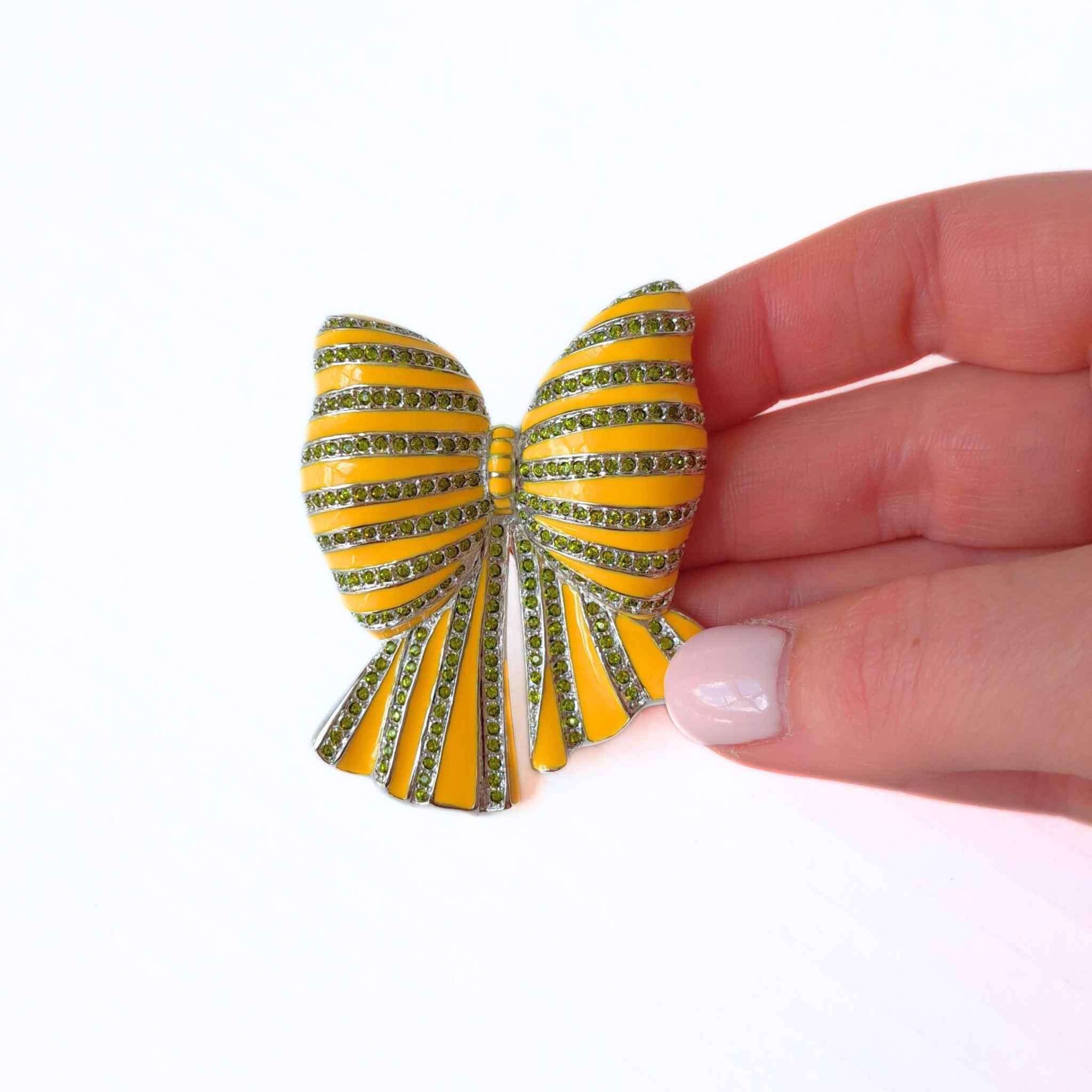 Bow Yellow Enamel and Crystal Brooch with hand pictured for scale