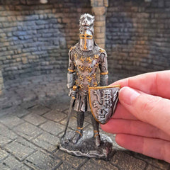 Metal state of a lion crested knight with hand pictured for scale