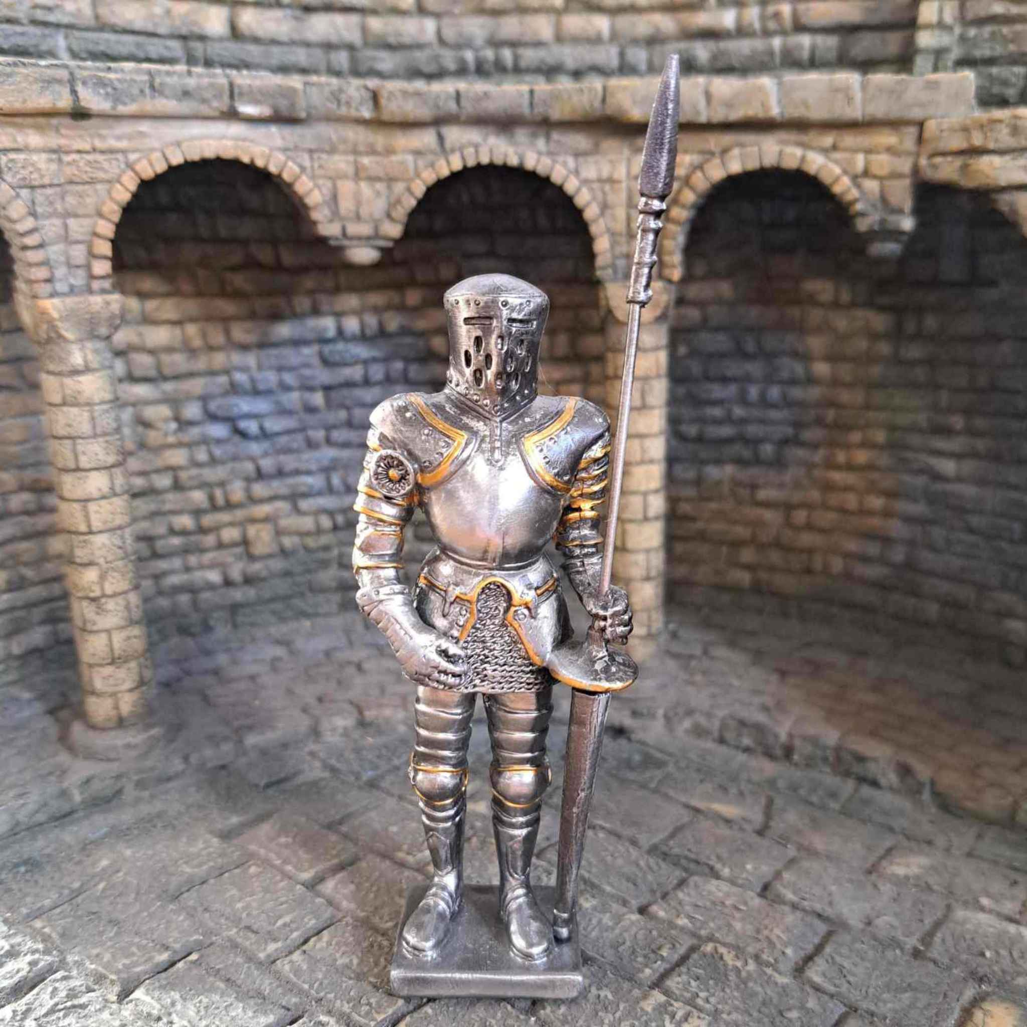 Jousting knight metal sculpture with medieval background close up view