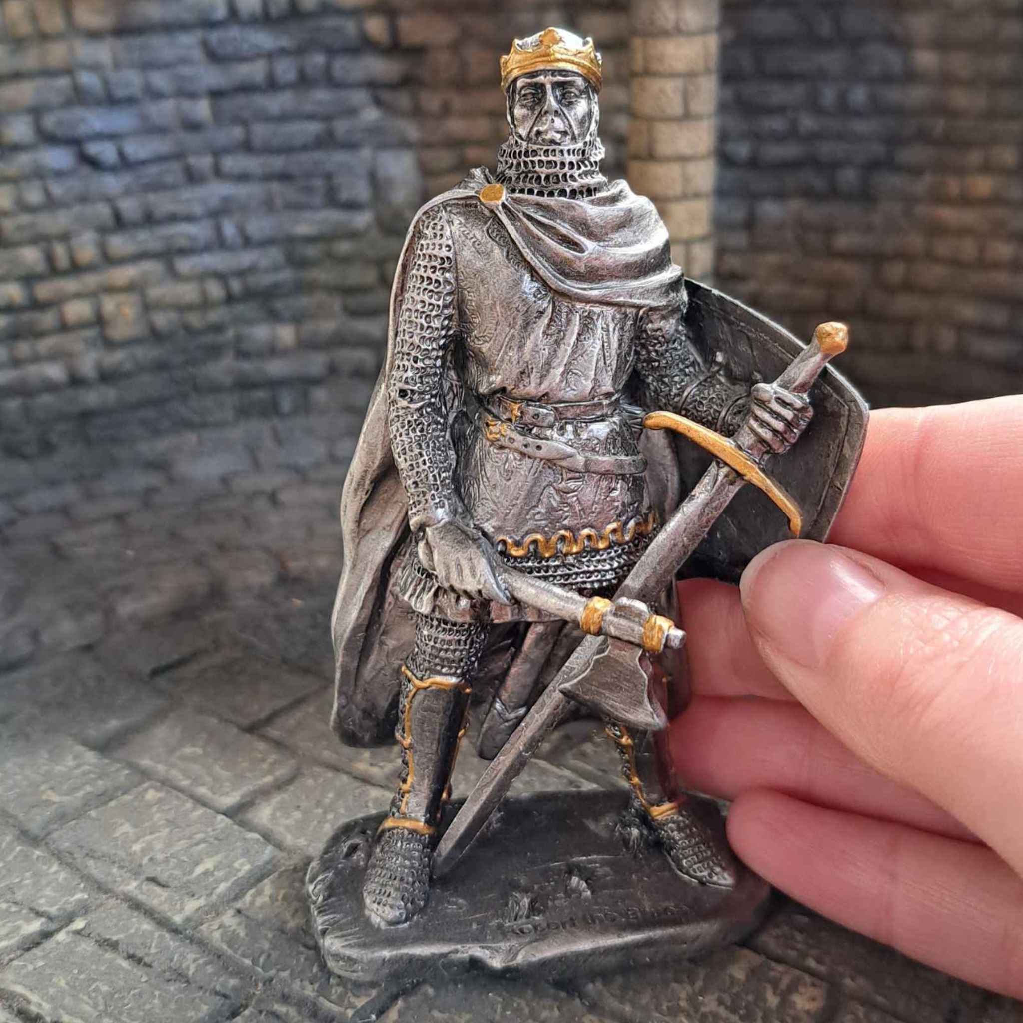 Robert the Bruce metal knight with hand pictured for scale