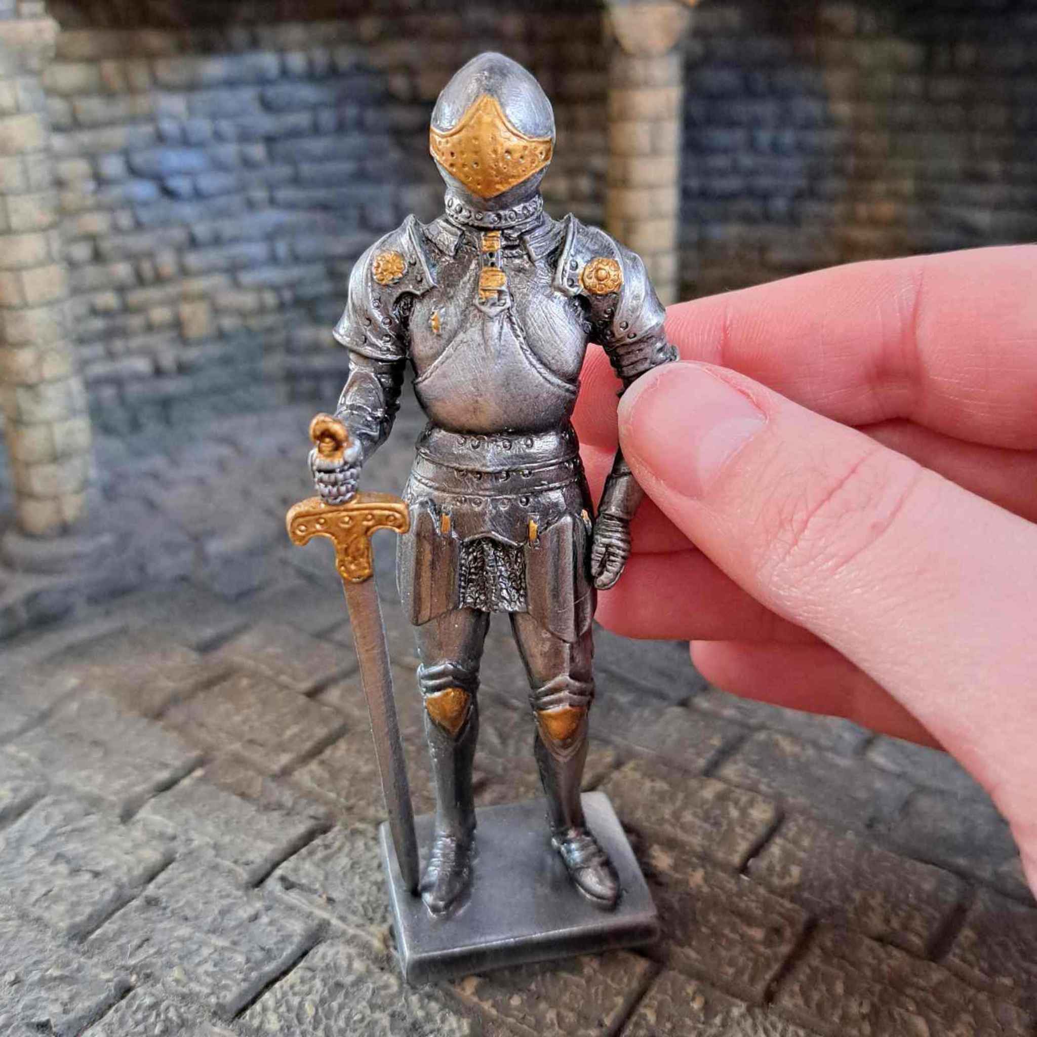 Knight in armour metal statue with hand pictured for scale